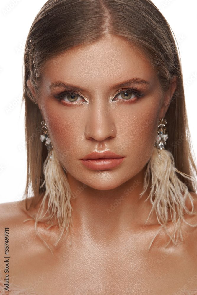 Girl fashion model with long straight hair wearing graceful feather earrings. Cosmetics and female accessories Girl fashion model with long straight hair wearing graceful feather earrings. Cosmetics and female accessories