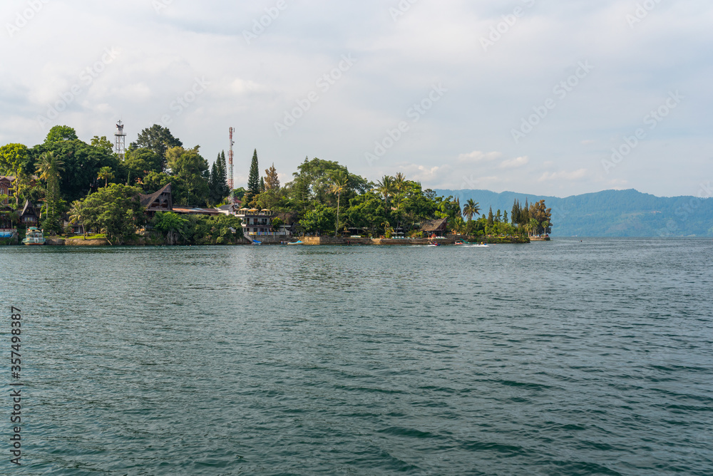 Fototapeta premium The island Samosir and peninsula Tuktuk Siadong with its resorts, within the Lake Toba, the biggest volcanic lake in the world located in the middle of the northern part of the island of Sumatra 