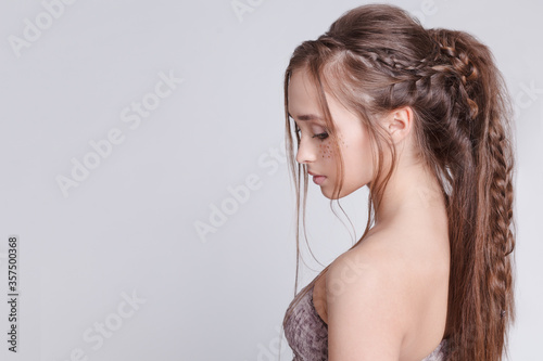 Bohemian style. Women Hairstyle with braid , romantic. Grey background. Copytext.