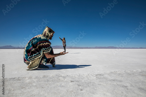Obraz na płótnie Couple playing with perspective in desert salt flats