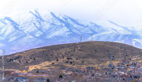 Panorama of houses and hilly terrain with magnificent snowy mountain background