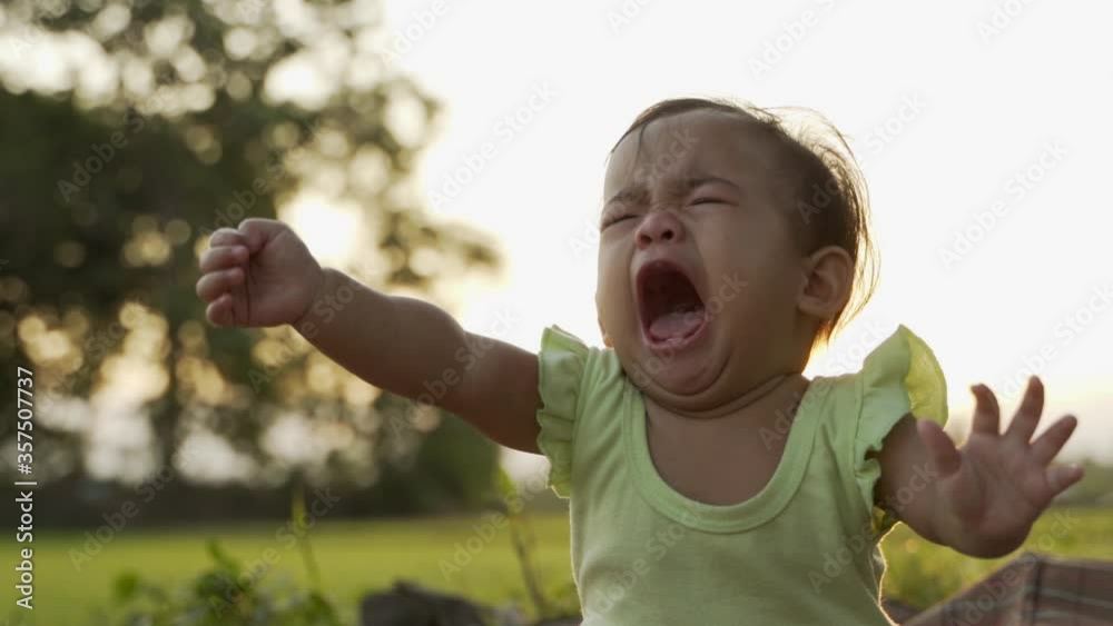 portrait close up of unhappy baby crying outdoor in the park portrait close up of unhappy baby crying outdoor in the park