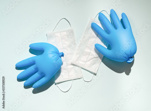 Flatlay with blue latex gloves and surgery masks on light blue background