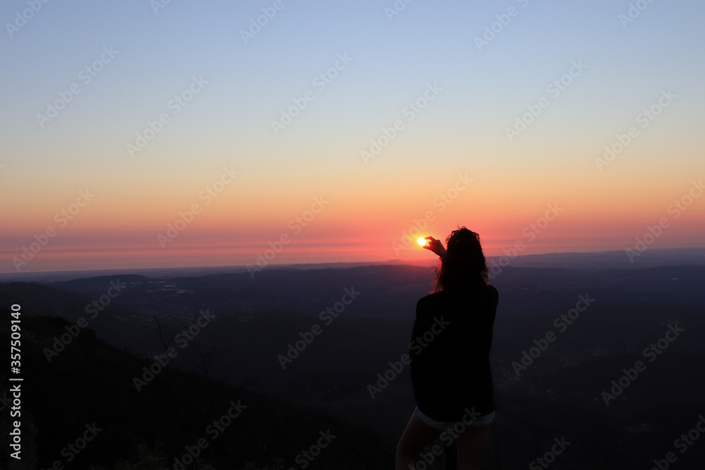 Woman holding the sun with her hands , Portugal
silhouette of woman at sunset