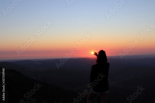 Woman holding the sun with her hands   Portugal silhouette of woman at sunset