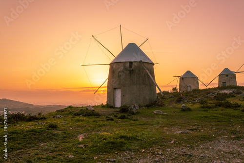 Lanscape with three old windmill by amazing sunset , in Coimbra , Portugal 