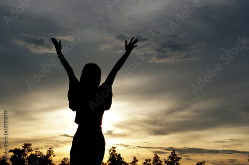 silhouette of women with both hands Get fresh air on the mountains.Freedom to live and travel