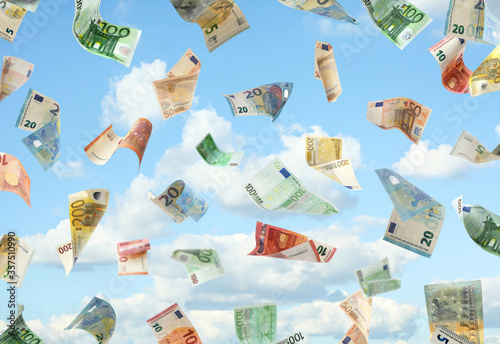 Falling Euro banknotes and blue sky on background. Money rain