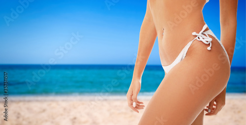 Sexy young woman wearing stylish bikini at beach on sunny day, closeup. Space for text