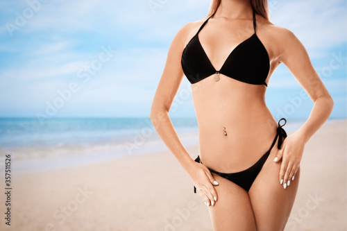 Young woman wearing stylish bikini at beach on sunny day, closeup. Space for text