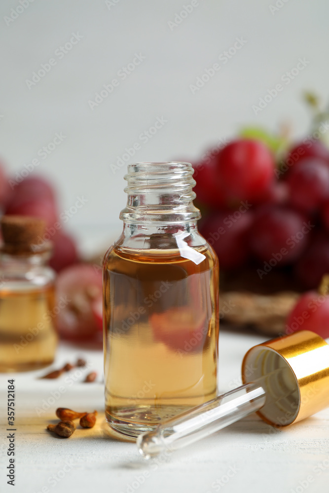 Bottle of natural grape seed oil on white wooden table. Organic cosmetic Bottle of natural grape seed oil on white wooden table. Organic cosmetic
