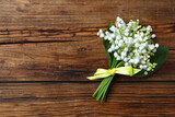 Beautiful lily of the valley flowers on wooden table, top view. Space for text
