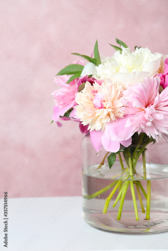 Bouquet of beautiful peonies in vase on white table