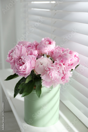 Bouquet of beautiful peonies on window sill