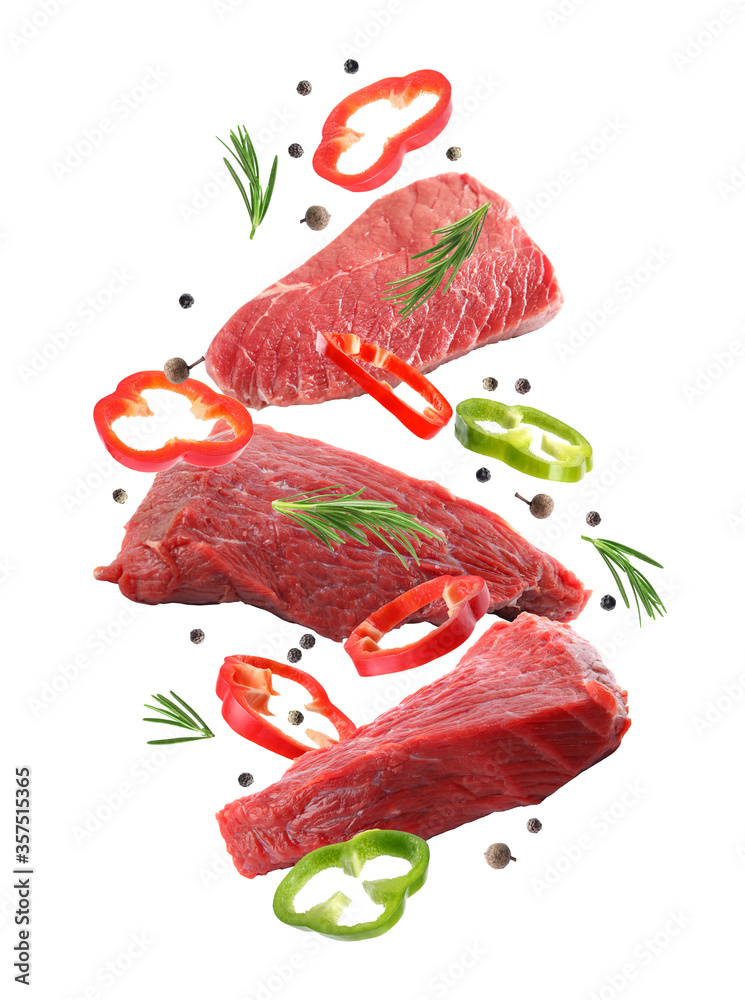 Raw beef meat and other ingredients falling on white background Stock ...