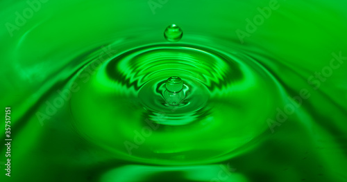 Close up of a drop of water in green water