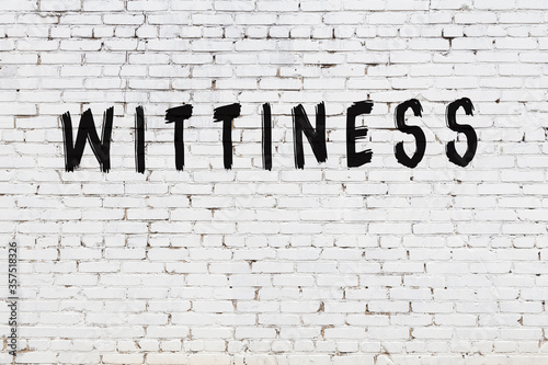 Word wittiness painted on white brick wall