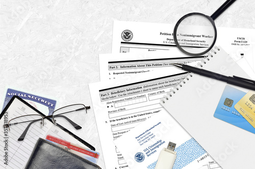 USCIS form I-129 Petition for a nonimmigrant worker lies on flat lay office table and ready to fill. U.S. Citizenship and Immigration services paperwork concept photo