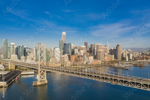 Aerial view of the San Francisco, California, skyline at sunrise. Ample copy space in blue sky. Bay bridge in foreground. © Patrick