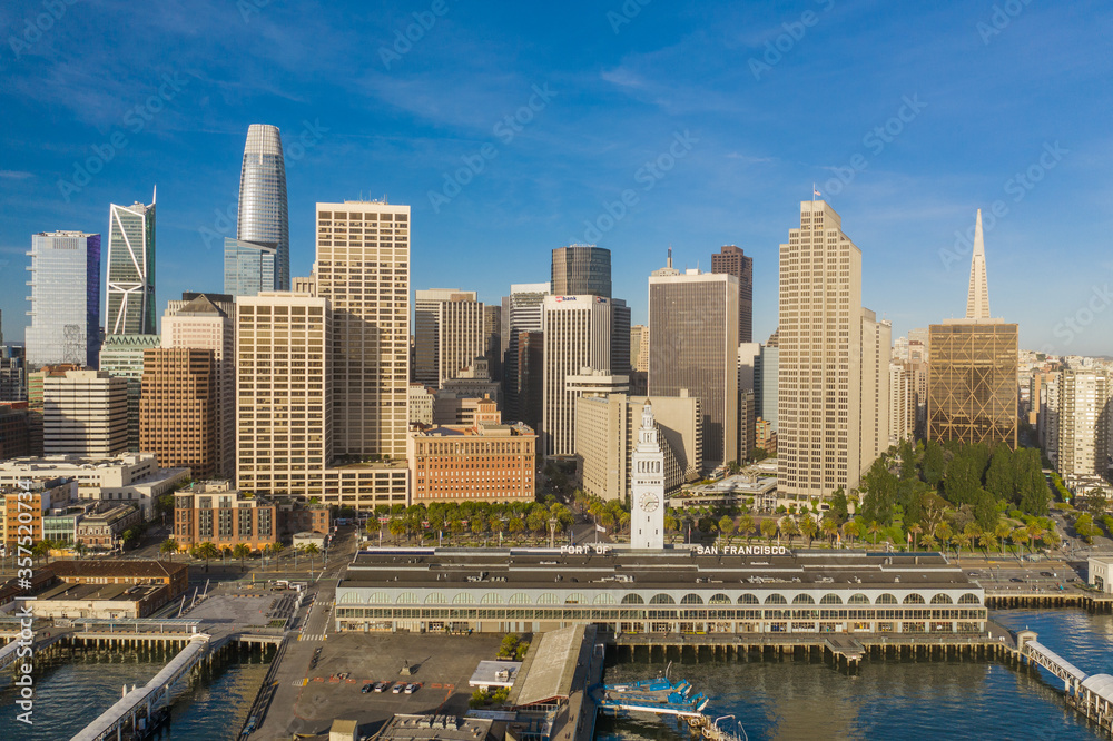 Fototapeta premium Aerial daytime view of the Embarcadero of the San Francisco, California, skyline. Ferry building in the foreground, ample copy space in blue sky. Morning light.