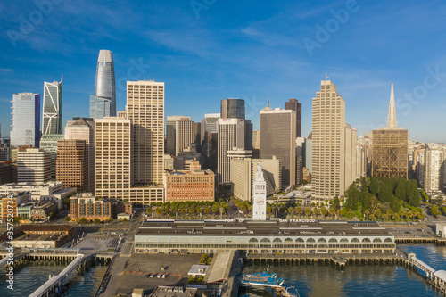 Fototapeta Naklejka Na Ścianę i Meble -  Aerial daytime view of the Embarcadero of the San Francisco, California, skyline. Ferry building in the foreground, ample copy space in blue sky. Morning light.