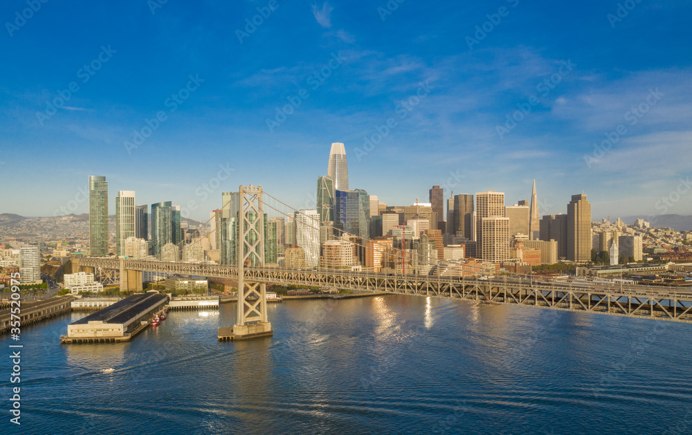 Obraz premium Aerial view of the San Francisco, California, skyline at sunrise. Ample copy space in blue sky. Bay bridge in foreground.