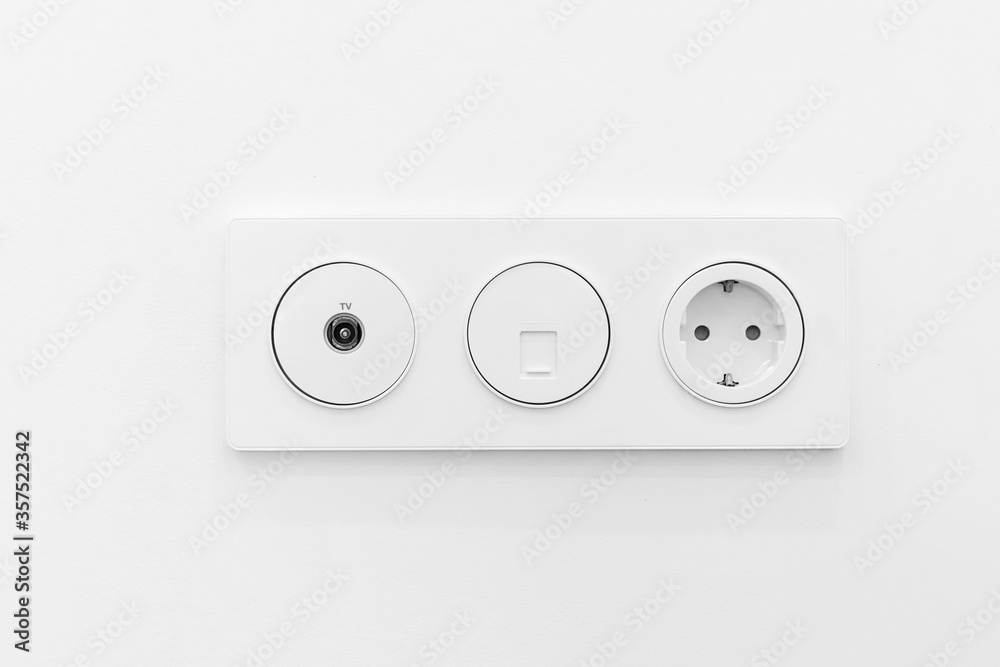 Socket on white wall, multifunction outlet with an internet connection, European-style outlet and TV connection