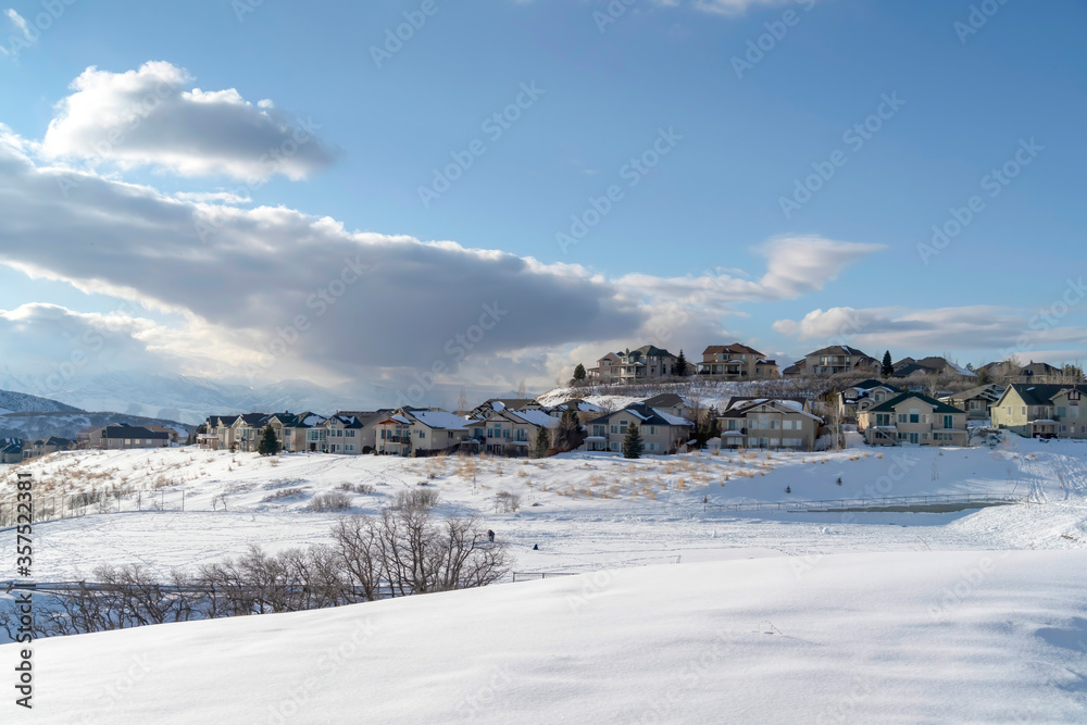 Wasatch Mountain in winter with houses on sunlit acres of snow covered terrain