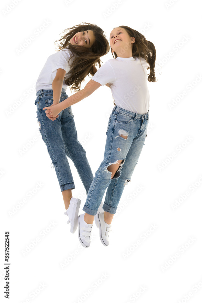 Two happy children jumping at once on a white background Two happy children jumping at once on a white background