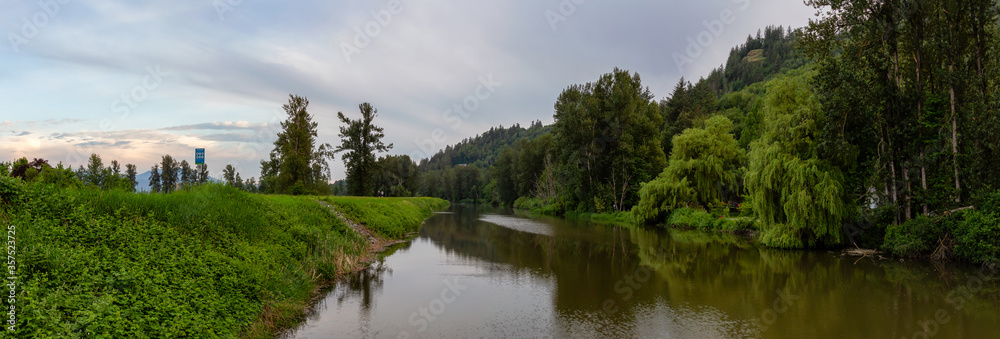 Beautiful Panoramic View of Sumas River during cloudy sunset. Taken in Abbotsford, East of Vancouver, British Columbia, Canada.