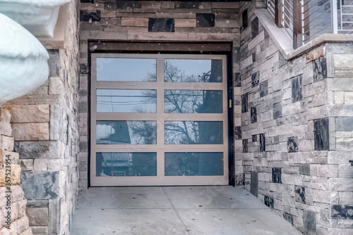 Close up of glass panel garage door of home with stonw brick exterior wall photo