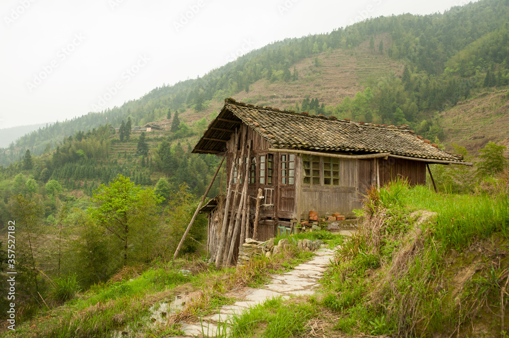 Old wooden structure situated on side of green forested hill in Longji, China. Over 100 years old. Old wooden structure situated on side of green forested hill in Longji, China. Over 100 years old.