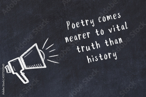 Chalk loudspeaker and wise quote on black desk photo