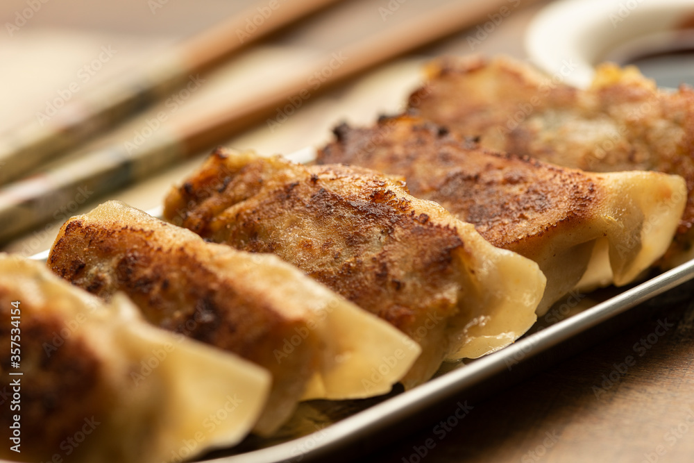 gyoza on silver plate wooden table chopsticks and soy sauce gyoza on silver plate wooden table chopsticks and soy sauce