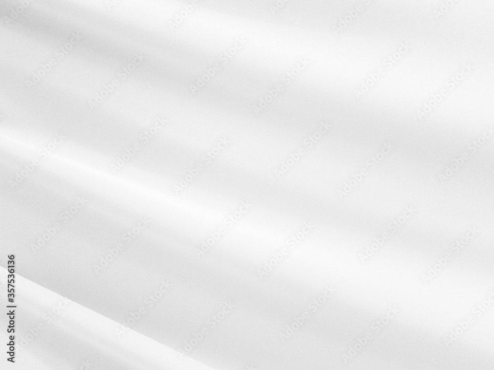 White silk satin background smooth texture background. The fabric is a light gray shining wave. White silk satin background smooth texture background. The fabric is a light gray shining wave.