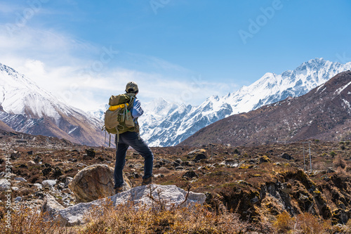 Young Asian woman trekker with backpack trekking in Langtang valley, travelling in Himalaya mountains range in Nepal