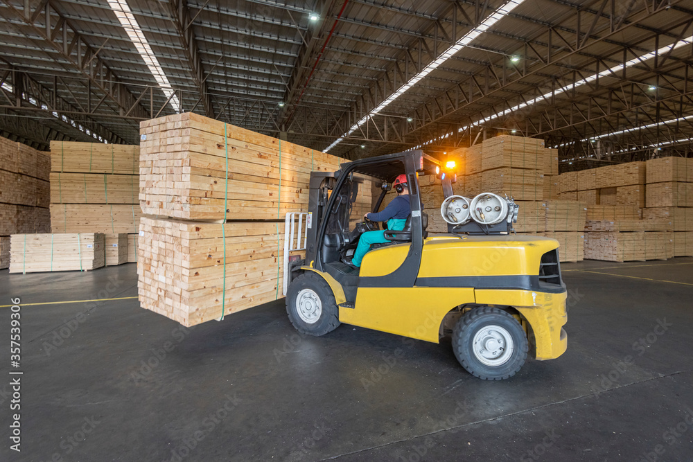 wood pallet forklift driving at a factory floor inside a shed