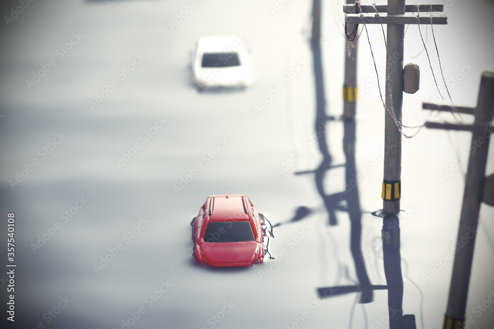Fototapeta premium 洪水で動けなくなった自動車と電信柱のジオラマ