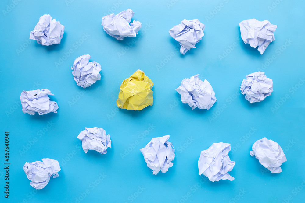 White with yellow crumpled paper balls on a blue background. White with yellow crumpled paper balls on a blue background.