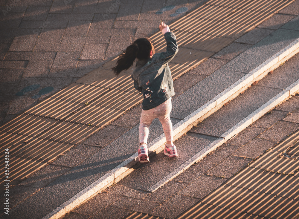 Obraz premium Kid playing in the street alone in London at Sunset