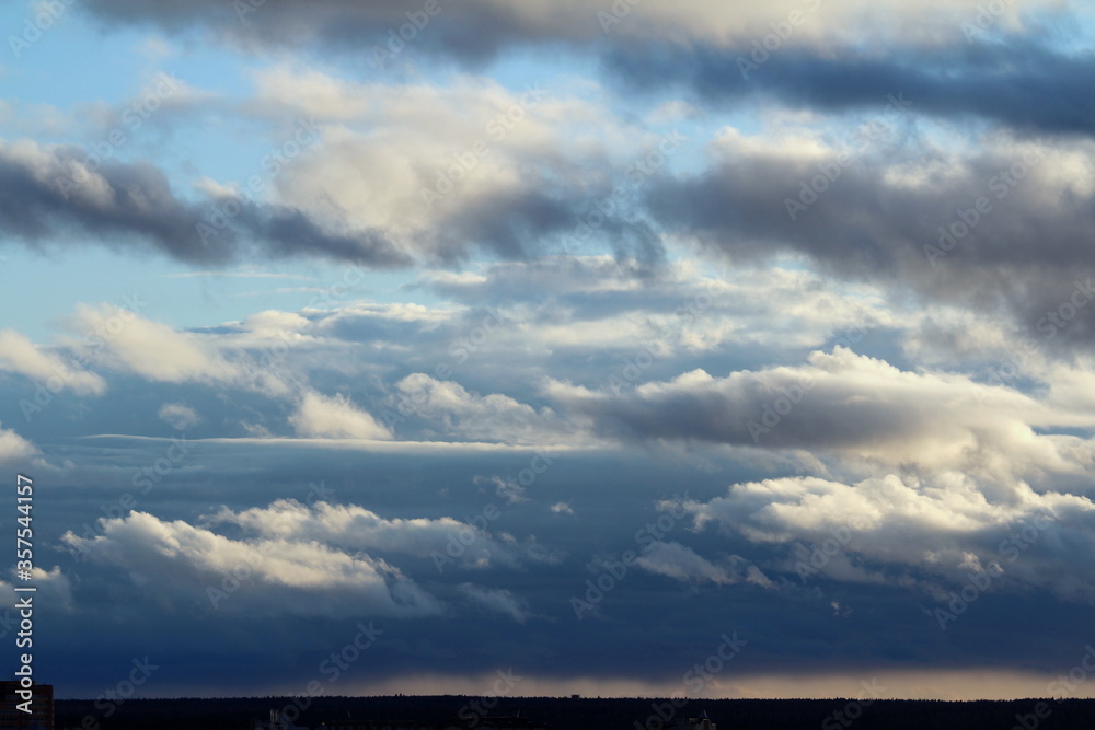 White fluffy clouds on a background of blue sky in summer over the horizon. The concept of weather and climate White fluffy clouds on a background of blue sky in summer over the horizon. The concept of weather and climate