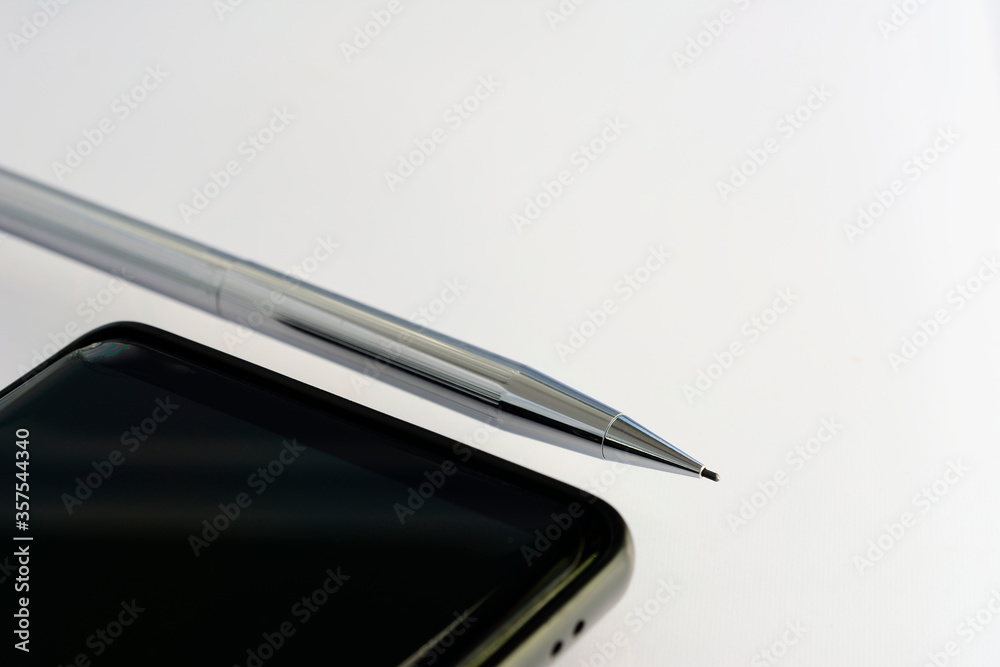 Silver chrome pencil and smartphone isolated on white background with empty space for mockup design. Silver chrome pencil and smartphone isolated on white background with empty space for mockup design.