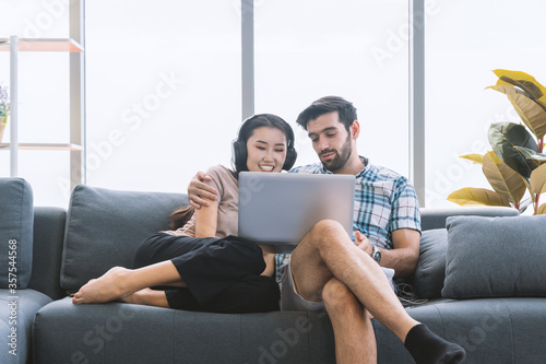 Young couple using laptop for meeting with internet at home.