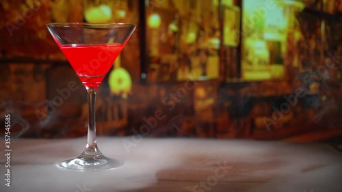 cocktail in a martini glass on bar background.