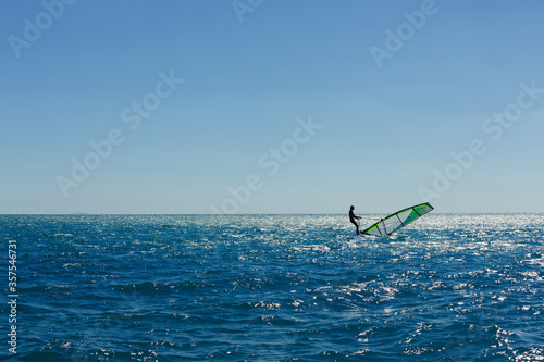 windsurfer panorama silhouette against a sparking blue sea