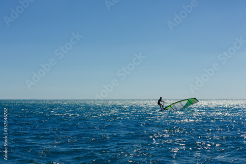 windsurfer panorama silhouette against a sparking blue sea