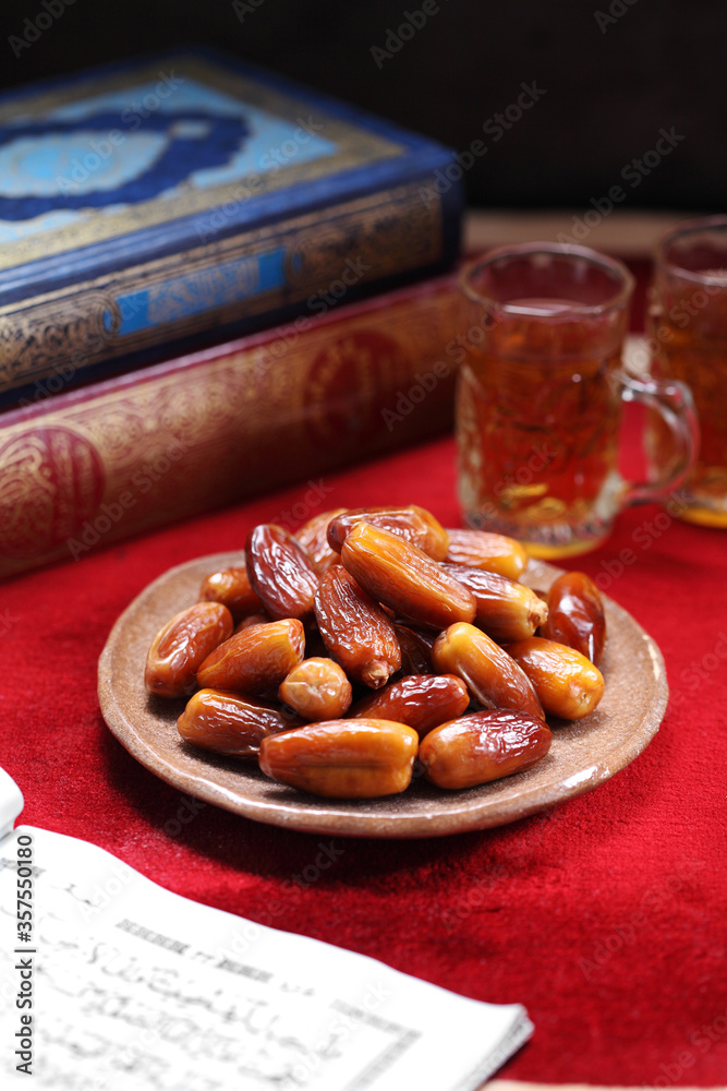 Fototapeta premium Dates fruit and Islamic Book Koran on carpet background