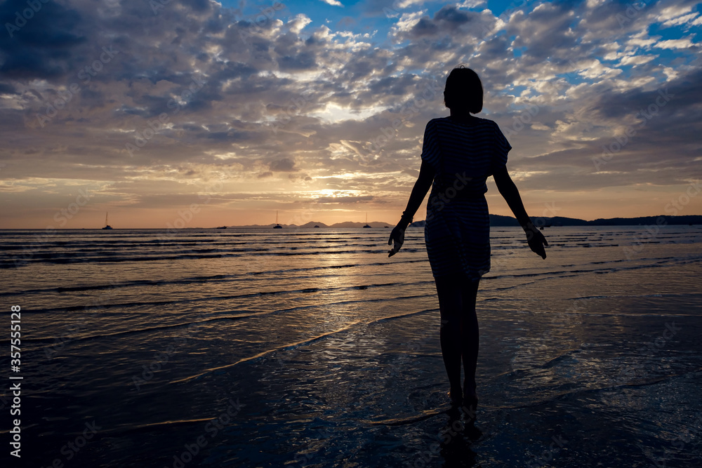 Happy Carefree Woman Enjoying Beautiful Sunset on the Beach