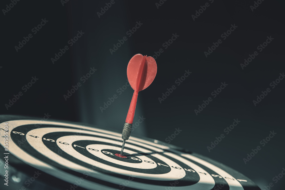 Bullseye or dart board has dart arrow throw hitting the center of a shooting target for business targeting and winning goals business concepts. Bullseye or dart board has dart arrow throw hitting the center of a shooting target for business targeting and winning goals business concepts.