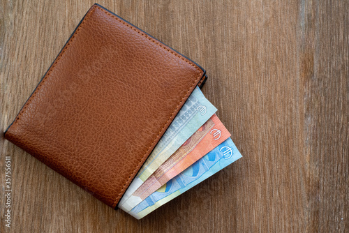 Obraz na płótnie New leather wallet with euro money on a wooden background w salonie